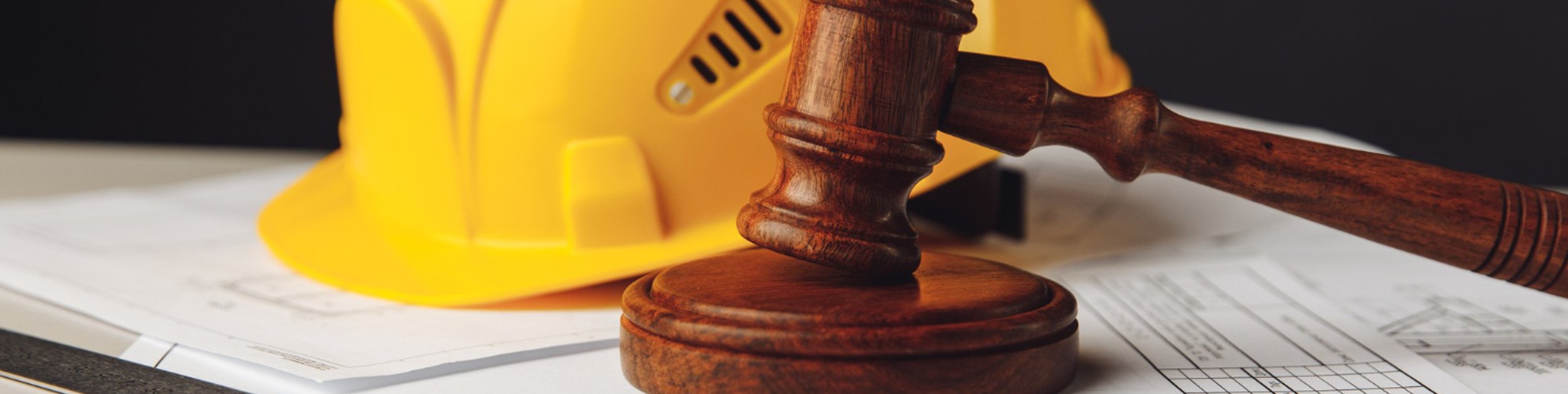 Construction litigation lawyer reviewing building plans and legal documents