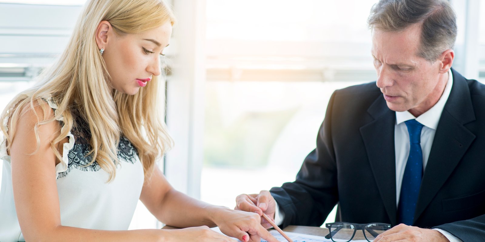 Legal professional examining a will document with magnifying glass